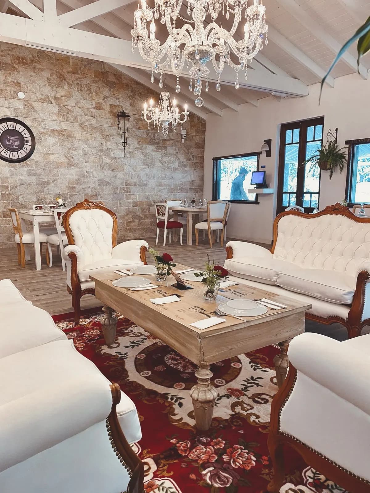 Salón con sillones capitoné, mesa ratona y arañas de cristal en Pasta Rossa Canning
